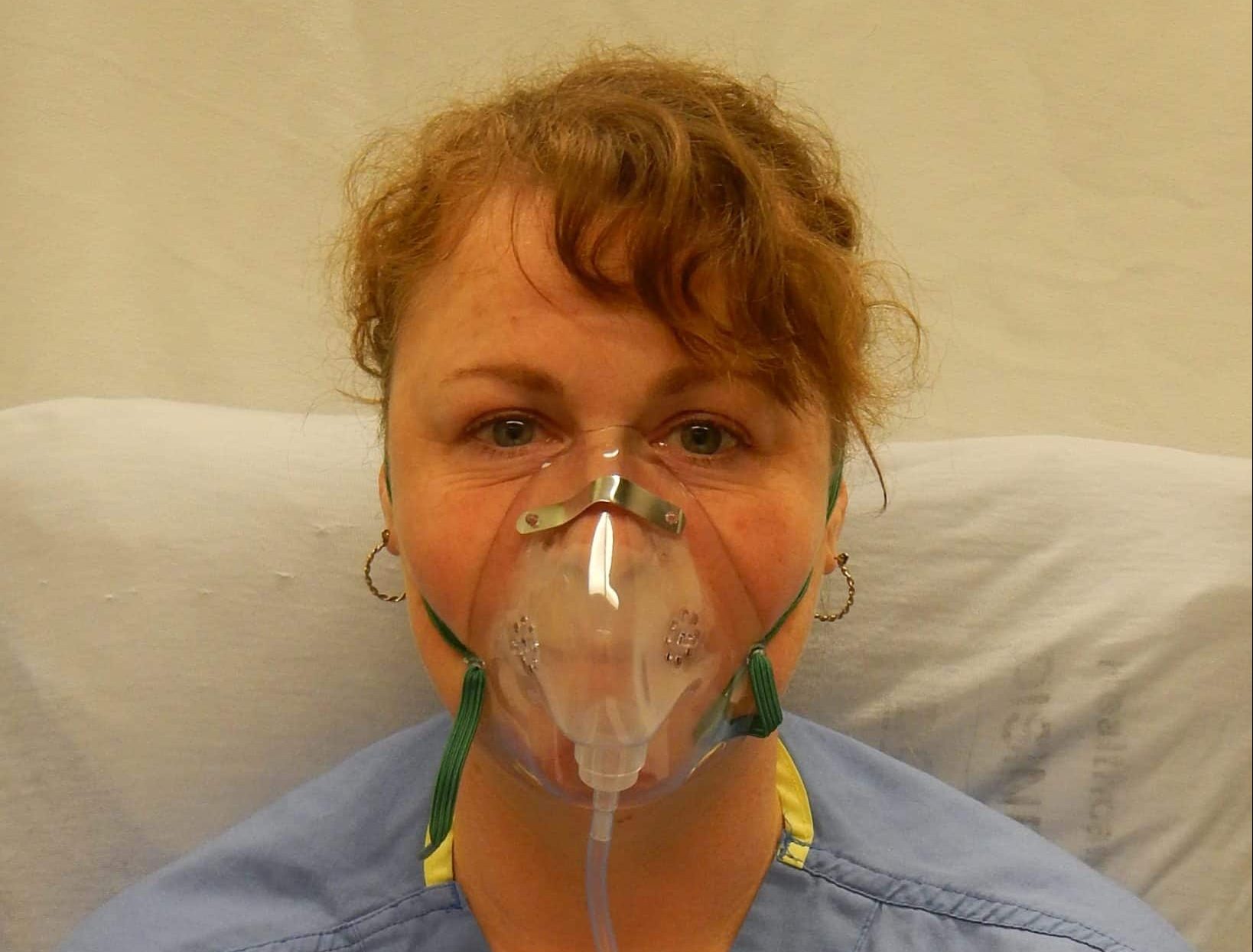 Зачем кислородные маски. Оксигенотерапия через кислородную маску. Человек в кислородной маске. Пациент с кислородной маской. Кислородная маска в больнице.